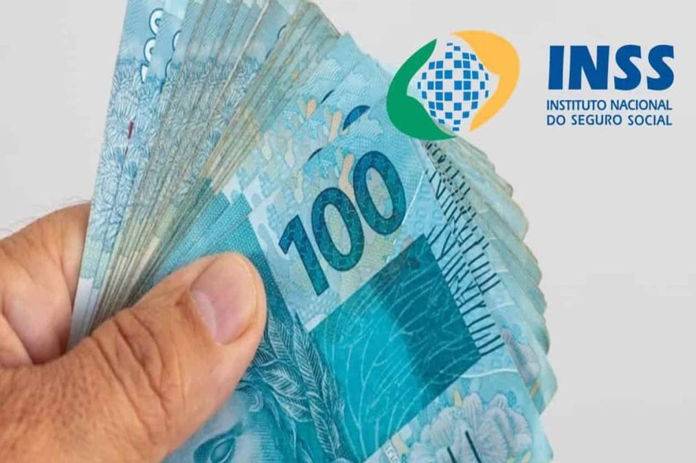 Homem segura notas de 100 reais; 13º salário do INSS