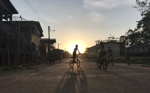Crianças andam de bicicleta ao entardecer na cidade