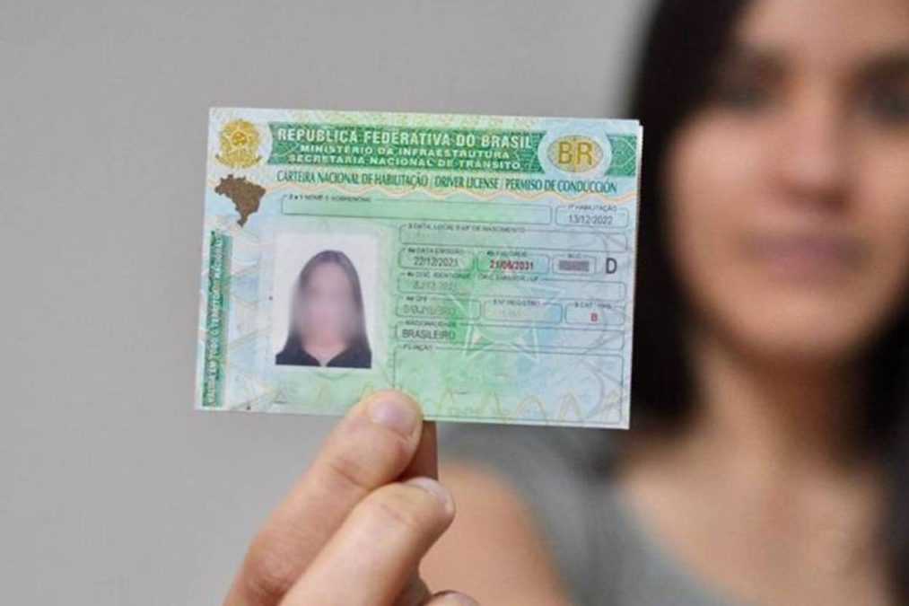 Mulher segura CNH, documento sem autoescola.
