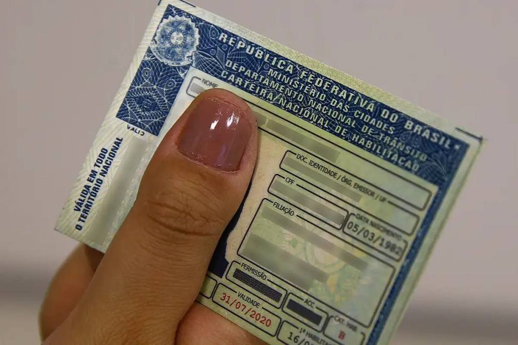 Mão segurando CNH; validade da CNH