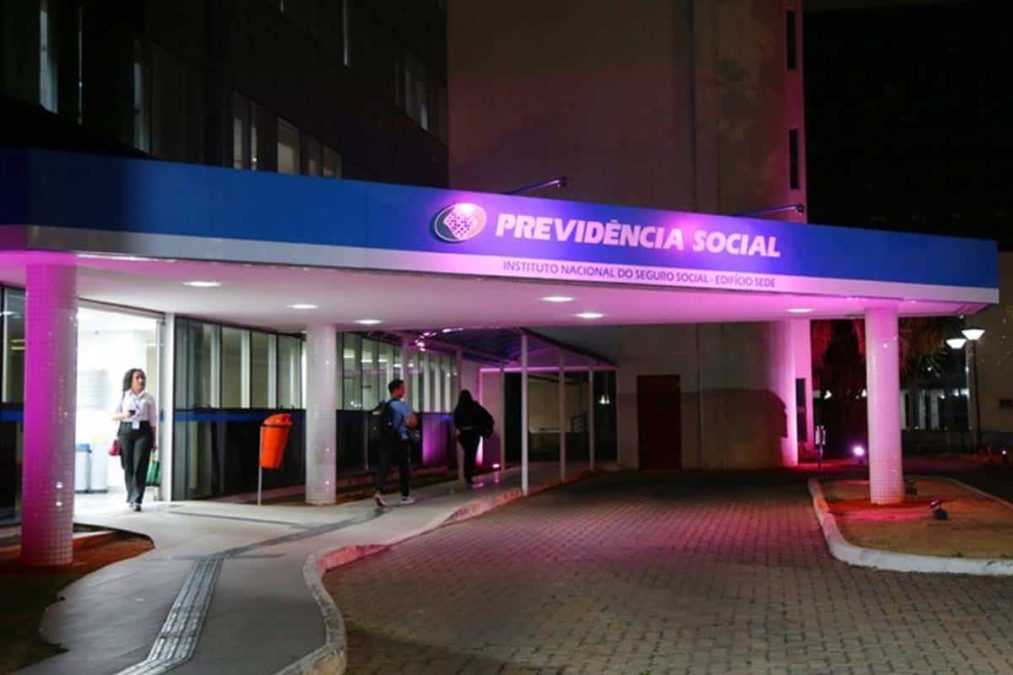Fachada do INSS iluminada em rosa no Outubro Rosa