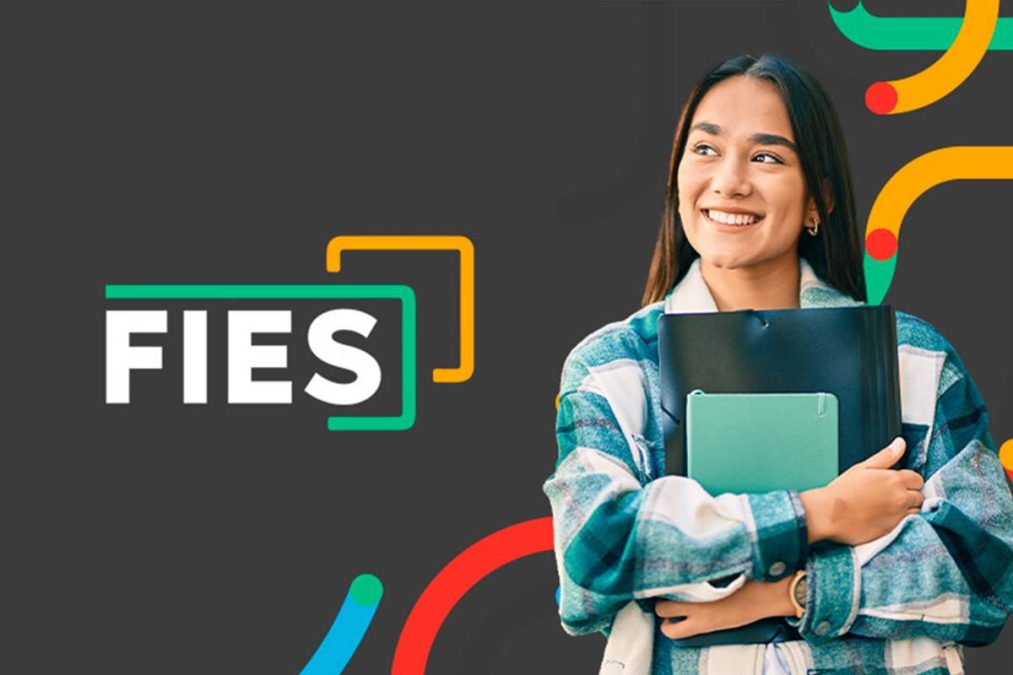 Estudante sorri segurando cadernos sobre o Fies 2025