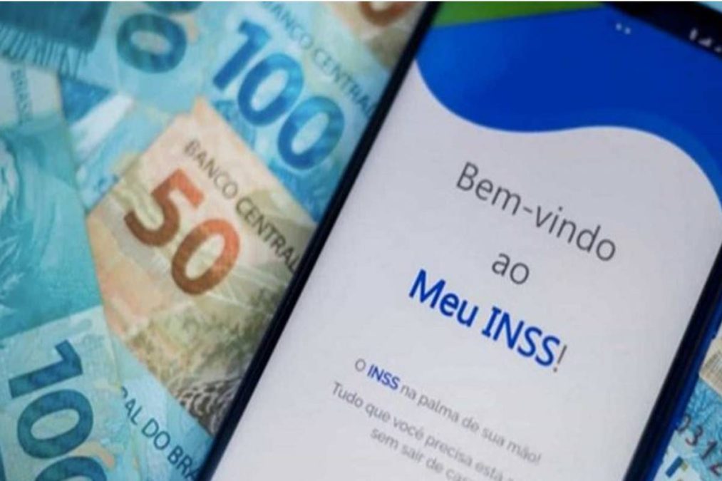 O ChatGPT disse: Tela do aplicativo Meu INSS ao lado de notas de real.