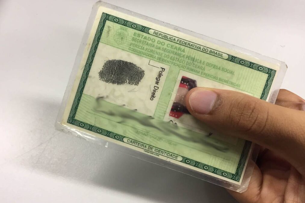 Segurando a Carteira de Identidade RG e os 3 motivos RG antigo ser recusado