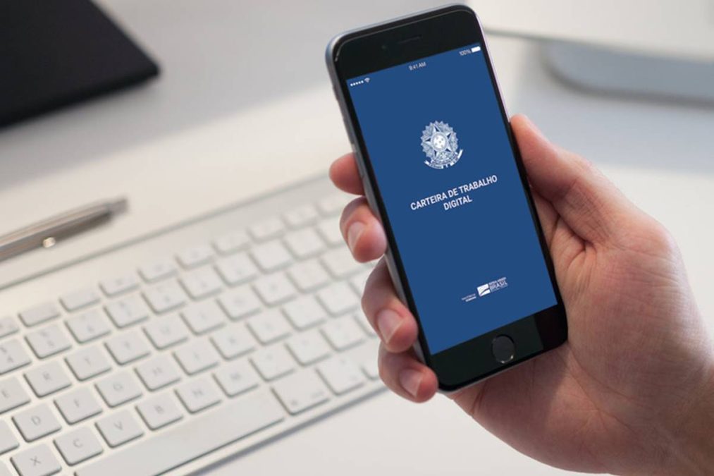 Pessoa segura um celular com o aplicativo Carteira de Trabalho Digital aberto na tela