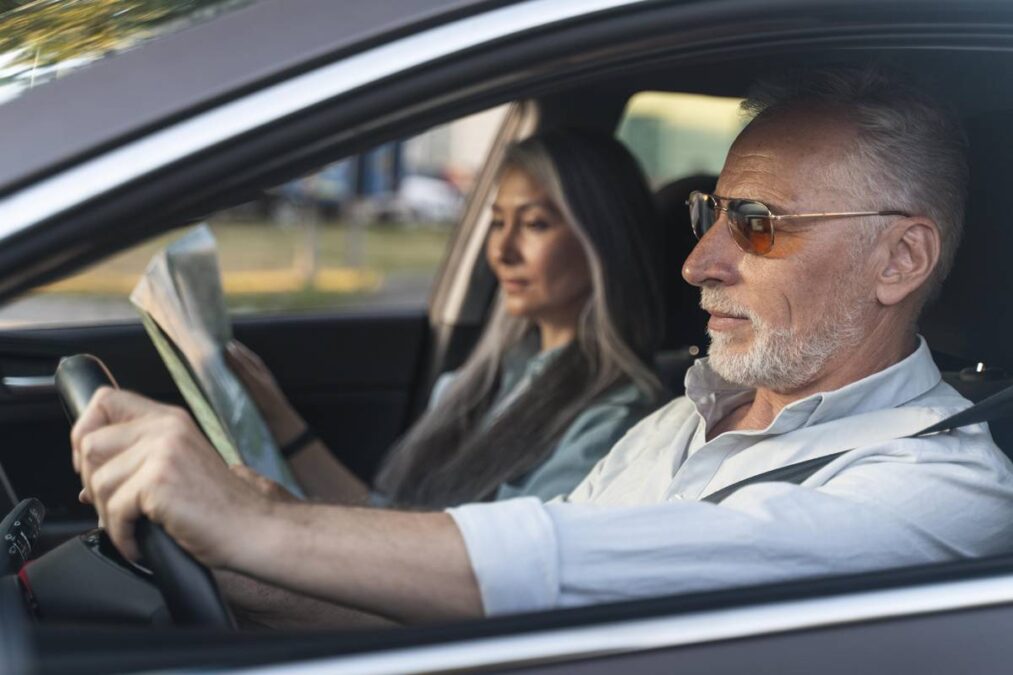 idoso dirigindo ao lado da esposa com a lei da CNH