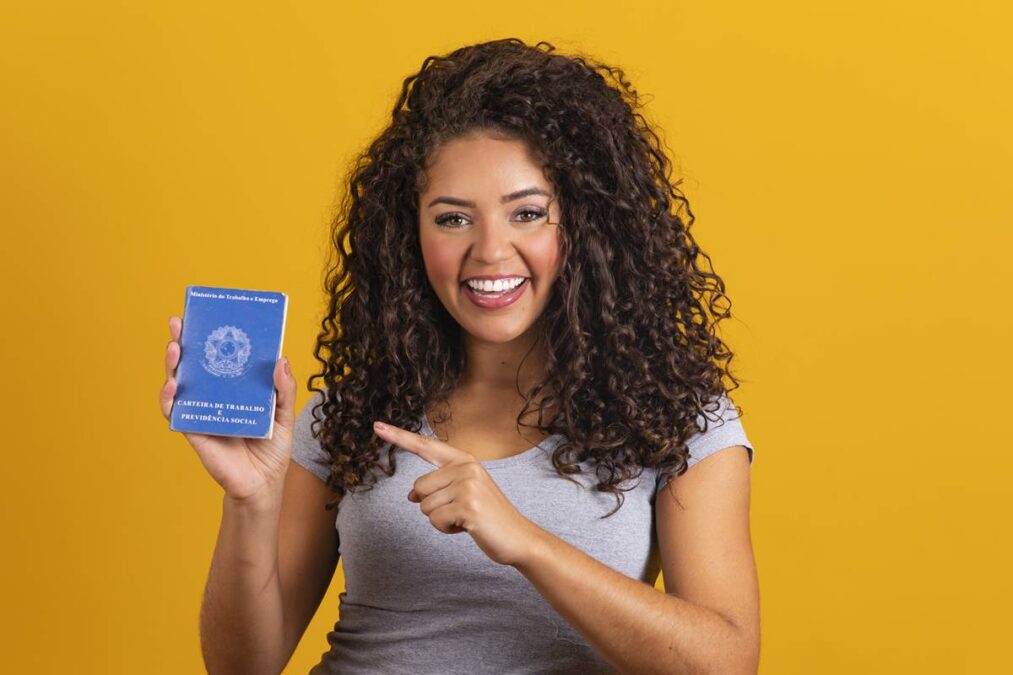 Mulher segura carteira de trabalho destacando 6 novas leis trabalhistas