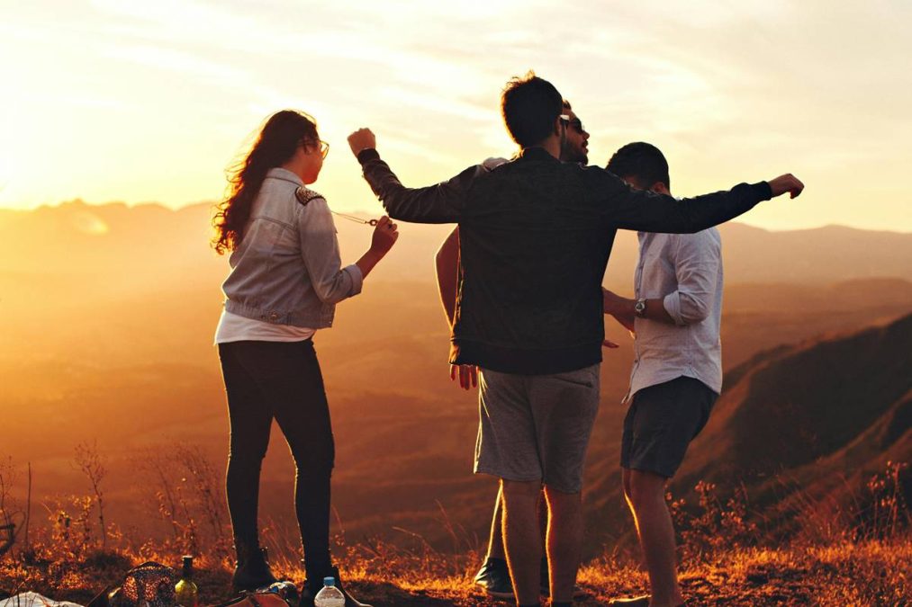 Quatro Pessoas Em Pé No Topo Da Montanha. Mês de outubro para esses signos