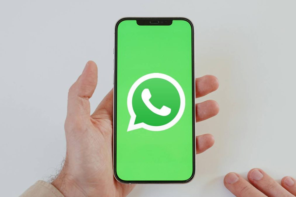 Mão segura celular com o WhatsApp