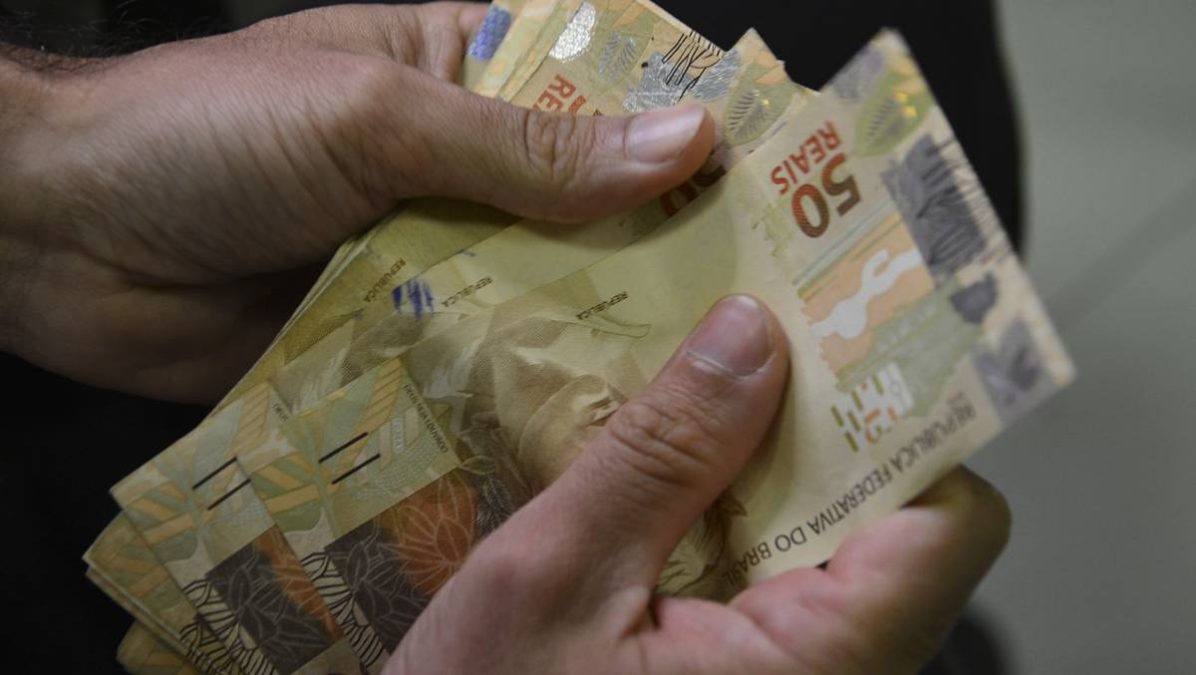 Aposentado do INSS contando dinheiro