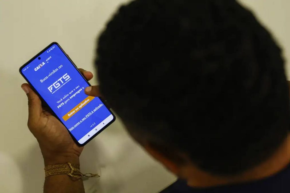 Pessoa acessa o aplicativo do FGTS no celular.