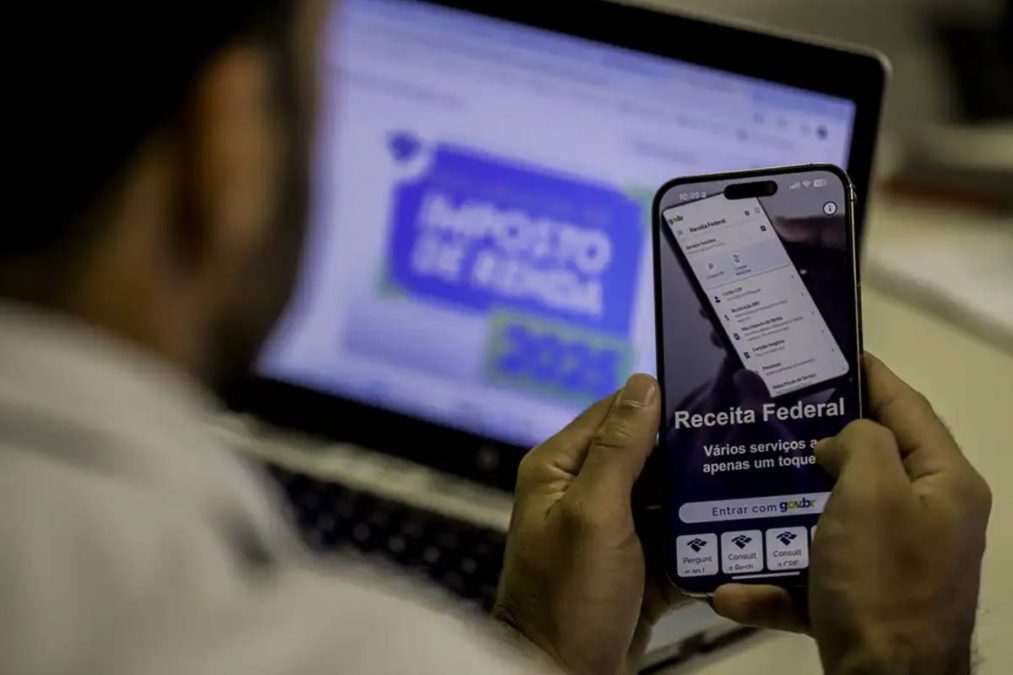 Homem com celular não pagando o Imposto de Renda